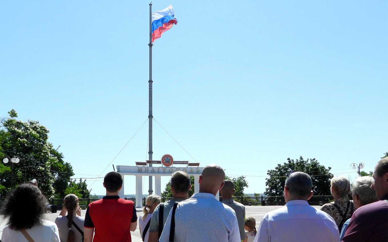 Masyarakat setempat mengambil bagian dalam upacara pengibaran bendera di Lapangan Kemenangan di Melitopol, wilayah Zaporizhzhya.  Alexei Konovalov / TASS