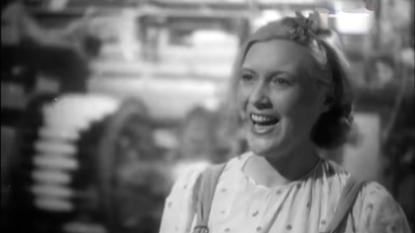 
					Lyubov Orlova sings as she works					 					A still from the movie "The Bright Path," 1940.				
