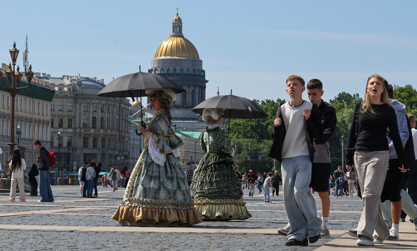 Tourists and costumed actors on Dvortsovaya Ploshchad in St. Petersburg. Alexander Demianchuk / TASS