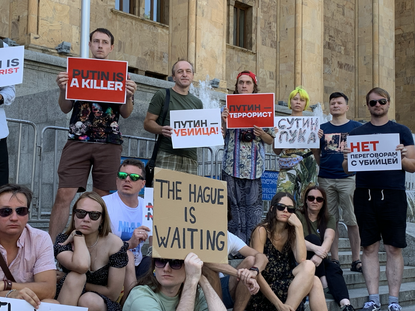 
					Protesters in front of Georgia’s parliament building holding signs that read “Putin is a terrorist” and “Say ‘no’ to negotiating with killers.” 					 					Mack Tubridy / MT				