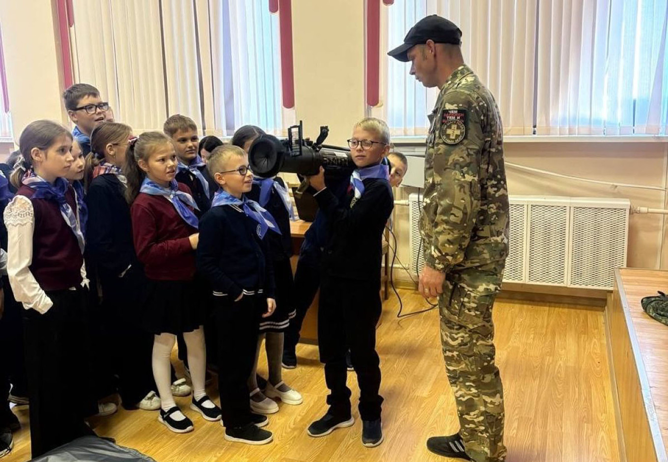 
					A Russian soldier instructs schoolchildren on holding a shoulder-launched munition.					 					ti71.ru				