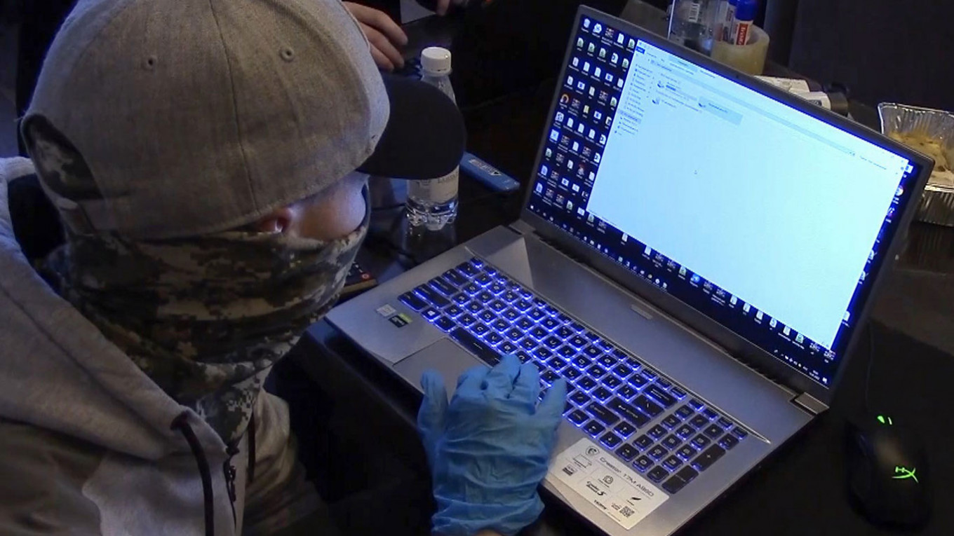 
					An FSB officer checks a laptop of a detained hacker.					 					FSS RF / TASS				