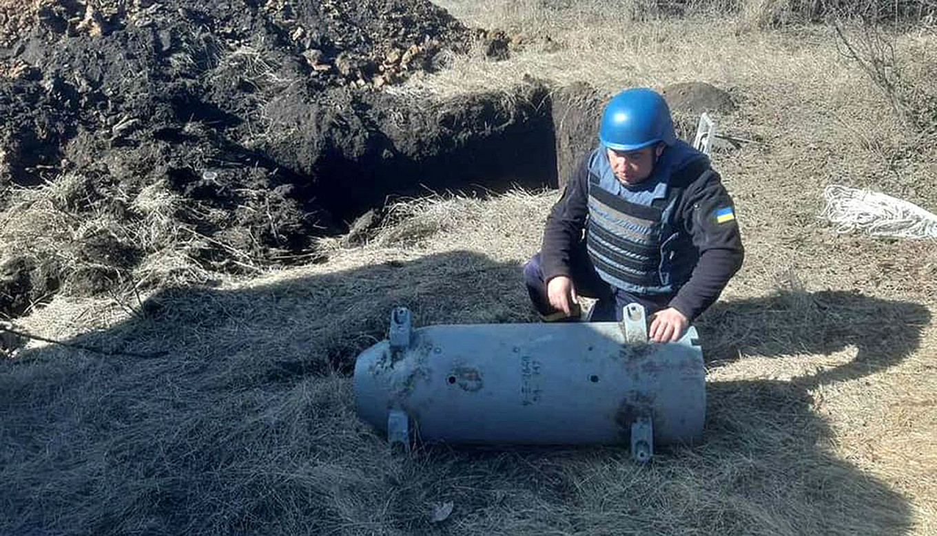A Ukrainian emergency services worker disposes of a warhead from a Russian Kalibr cruise missile.  State Emergency Service of Ukraine