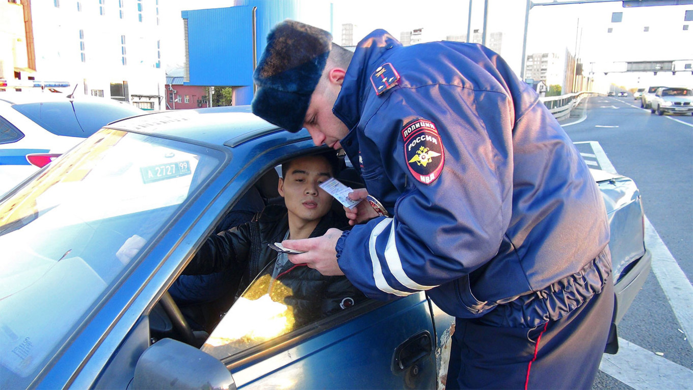 
					A police officer in Moscow checks a man's documents.					 					Moskva News Agency				