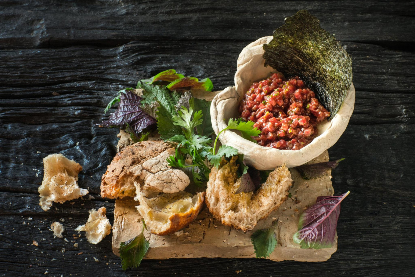 
					Sempre's beef tartare is served on a stone platter with seaweed paper and aromatic fresh greens.					 					SEMPRE / FACEBOOK				