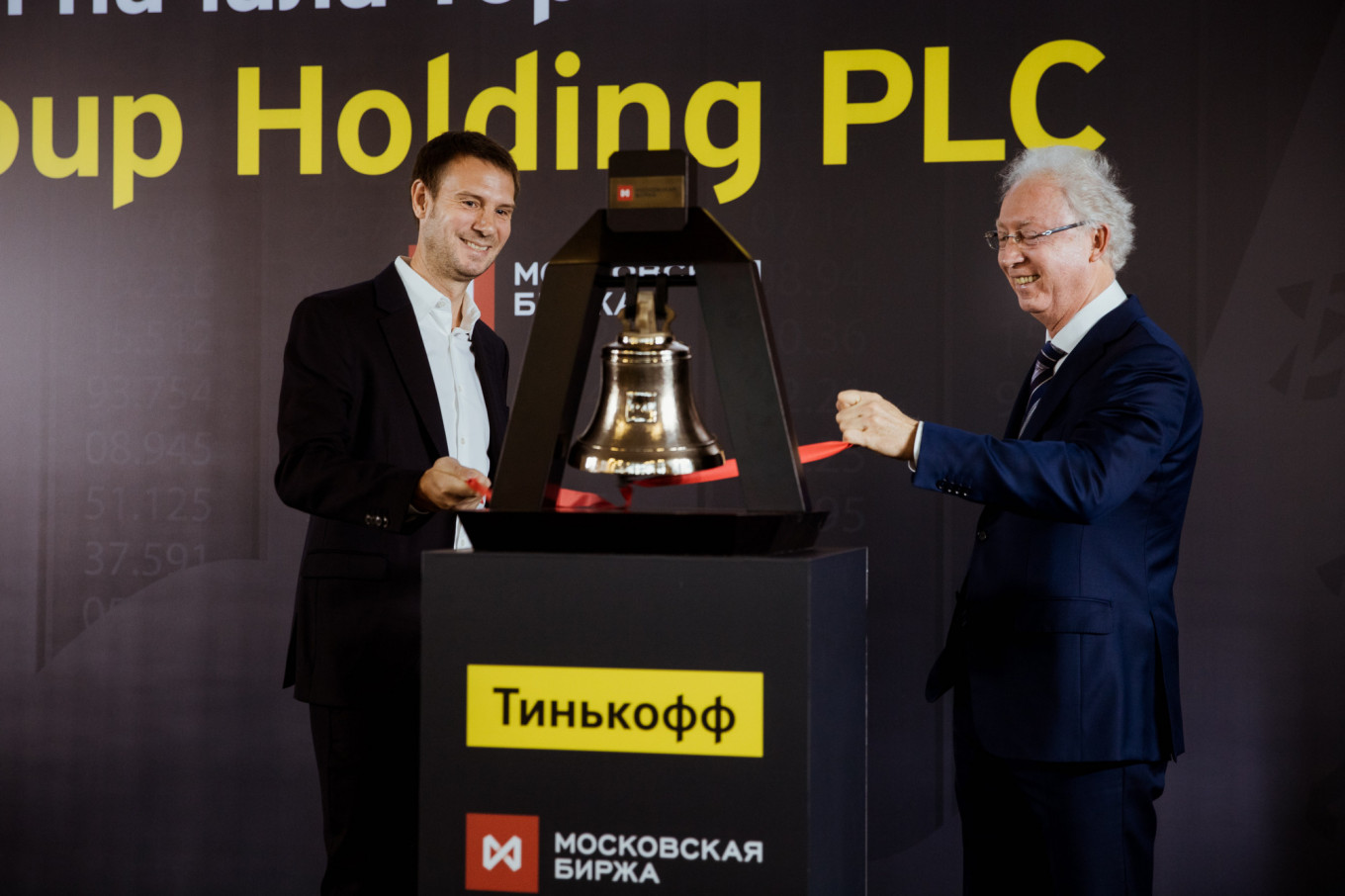 
					Tinkoff CEO Oliver Hughes and Oleg Vyugin of the Moscow Exchange ring the stock market's opening bell at a ceremony to mark the launch of Tinkoff's secondary listing.					 					Tinkoff Bank Media				