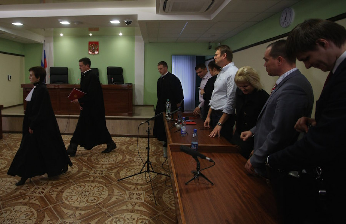 Alexei Navalny menyaksikan hakim meninggalkan ruang sidang pada akhir persidangan di pengadilan Kirov di Kirov, Rusia, 16 Oktober 2013. Evgeny Feldman/AP