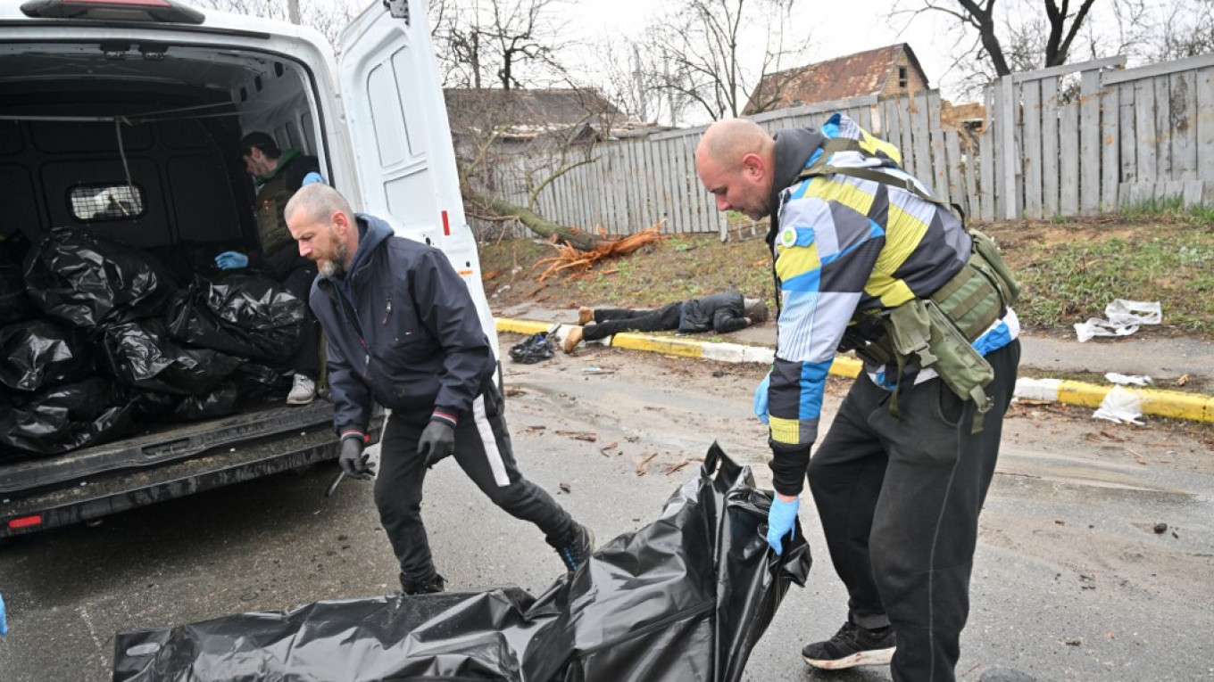 
					Communal workers load a van with body bags of people killed during Russian shelling in the town of Bucha, not far from the Ukrainian capital of Kyiv on April 3. 					 					Sergei Supinsky / AFP				