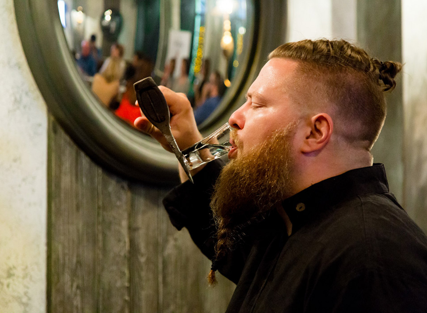 
					Alexei Semyonov, chef at the Russian Pub, balancing his shot glass on an axe.					 									