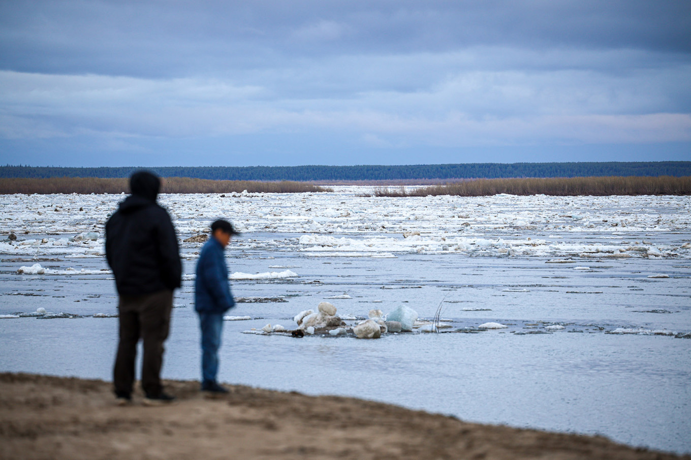 
					People look at floating ice on the Lena River. 					 					Vadim Skryabin / TASS				