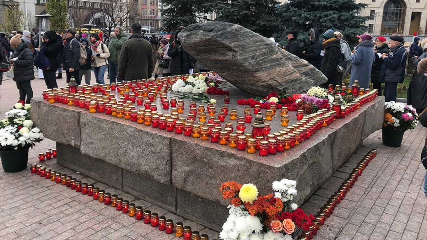 
					Muscovites laid flowers and placed candles at the base of the Solovetsky Stone in remembrance of the victims of Stalin.					 					Evan Gershkovich / MT				