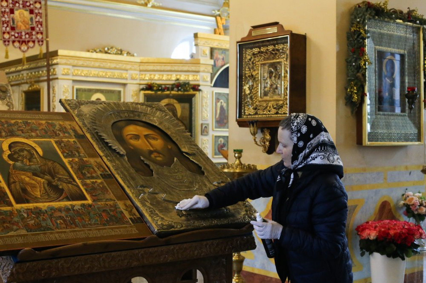 
					A worker disinfects an icon with an alcohol solution in the Church of St. Alexis in Rogozhskaya Sloboda.					 					Sergei Vedyashkin / Moskva News Agency				