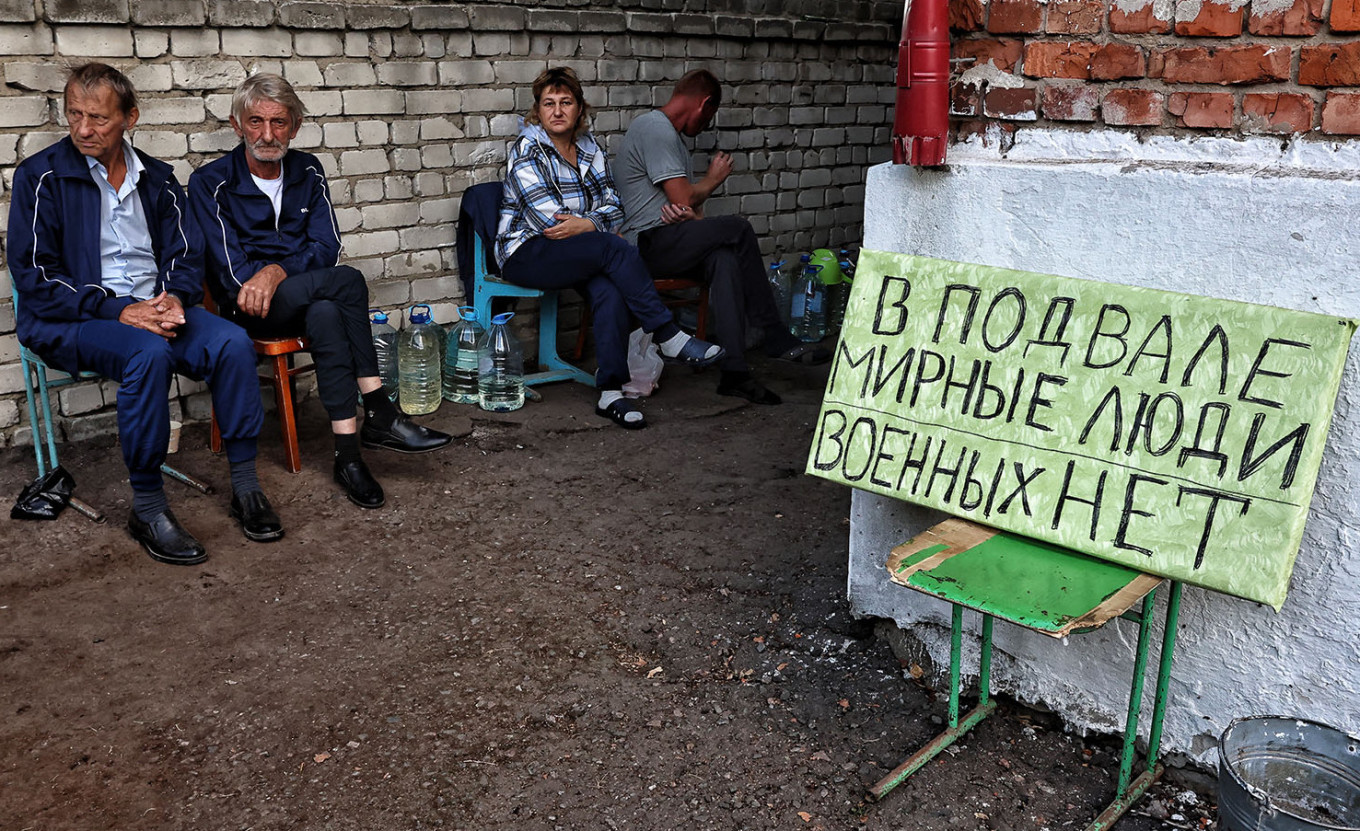 
					Elderly residents sit beside a sign that reads "There are civilians in the basement, no military" in Sudzha, Kursk region.					 					Yan Dobronosov / AFP				