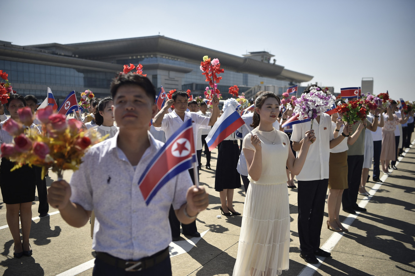 North Koreans take part in a ceremony to welcome Russia's Nordwind Airlines' Boeing 777 at Pyongyang International Airport in July 2025, completing the first commercial leg in decades between capitals of the allied countries.