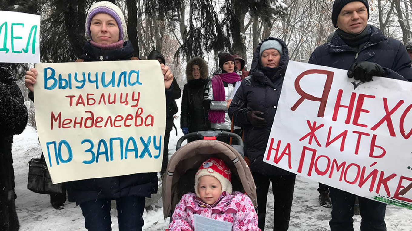 
					Protesters at the demonstration on December 9 hold signs, which read "I've learned the periodic table by smell" and "I don't want to live on a dump." 					 					Evan Gershkovich				