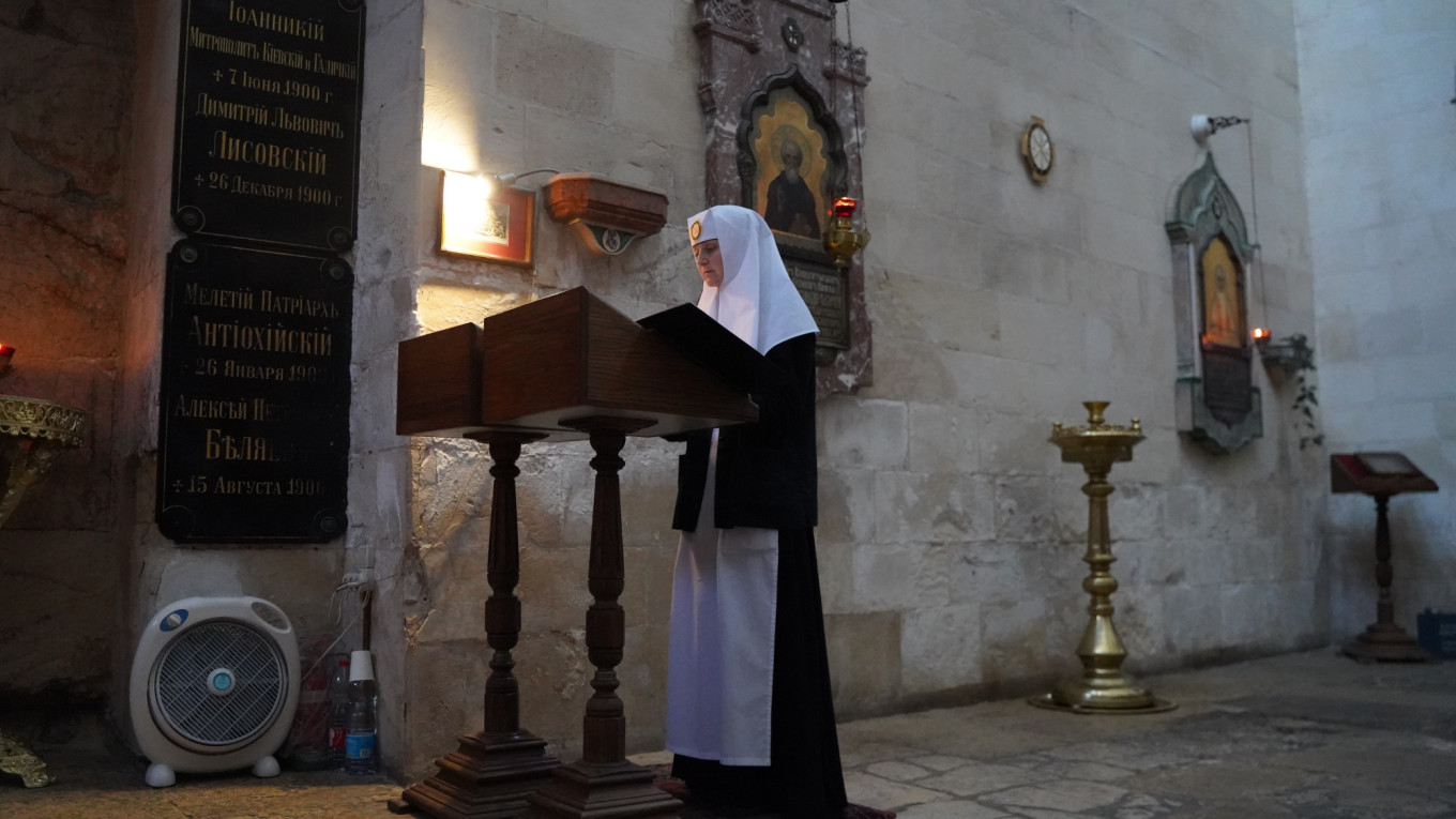 
					Sister Ioanna praying in front of the Threshold of the Judgement Gate in Jerusalem.					 					Iryna Matviyishyn				