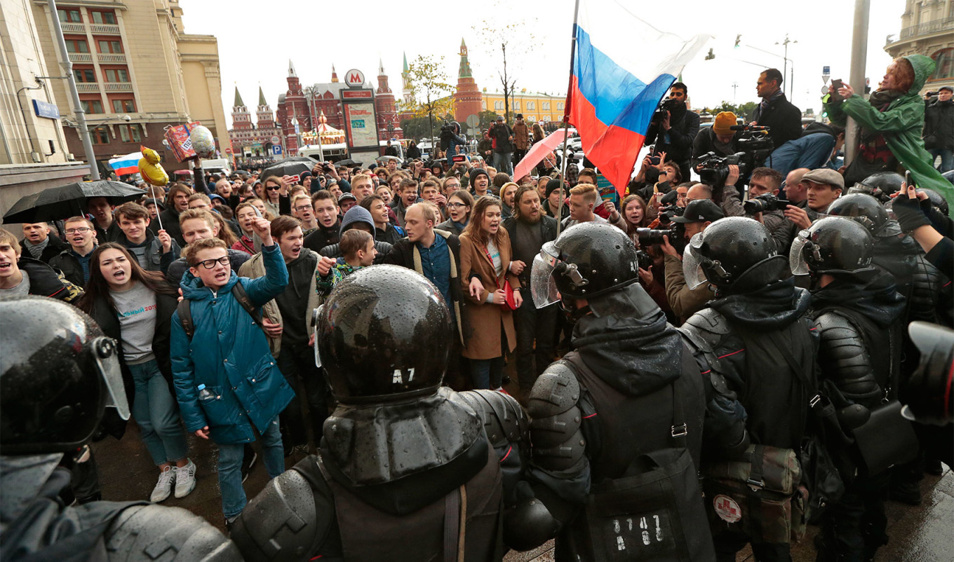 Riot police officers block protesters with Russian flags during a rally in Moscow, Russia, Oct. 7, 2017. Ivan Sekretarev / AP Photo / TASS