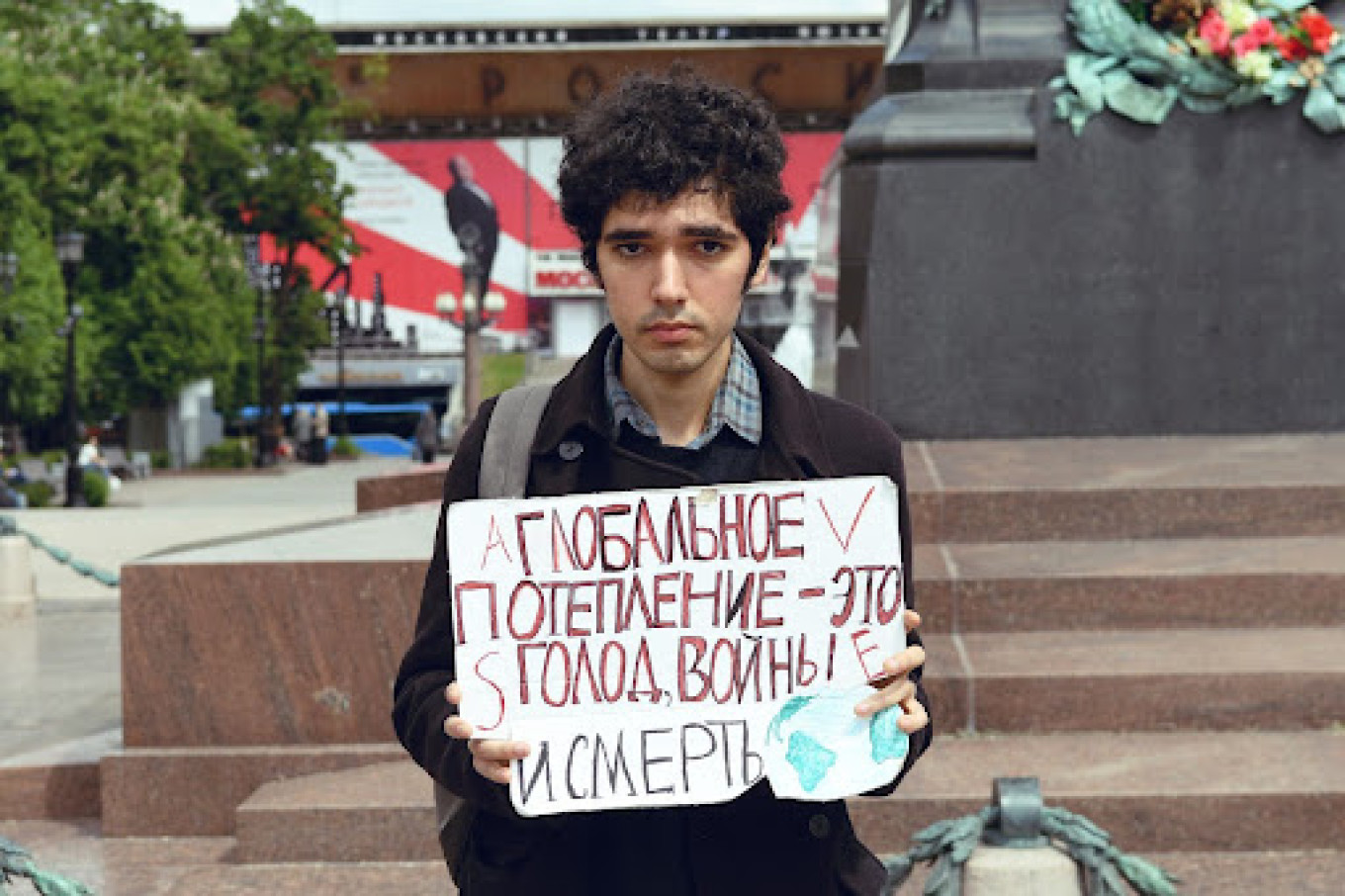 
					The author holding a sign reading “global warming is hunger, wars and death."					 					Arshak Makichyan				