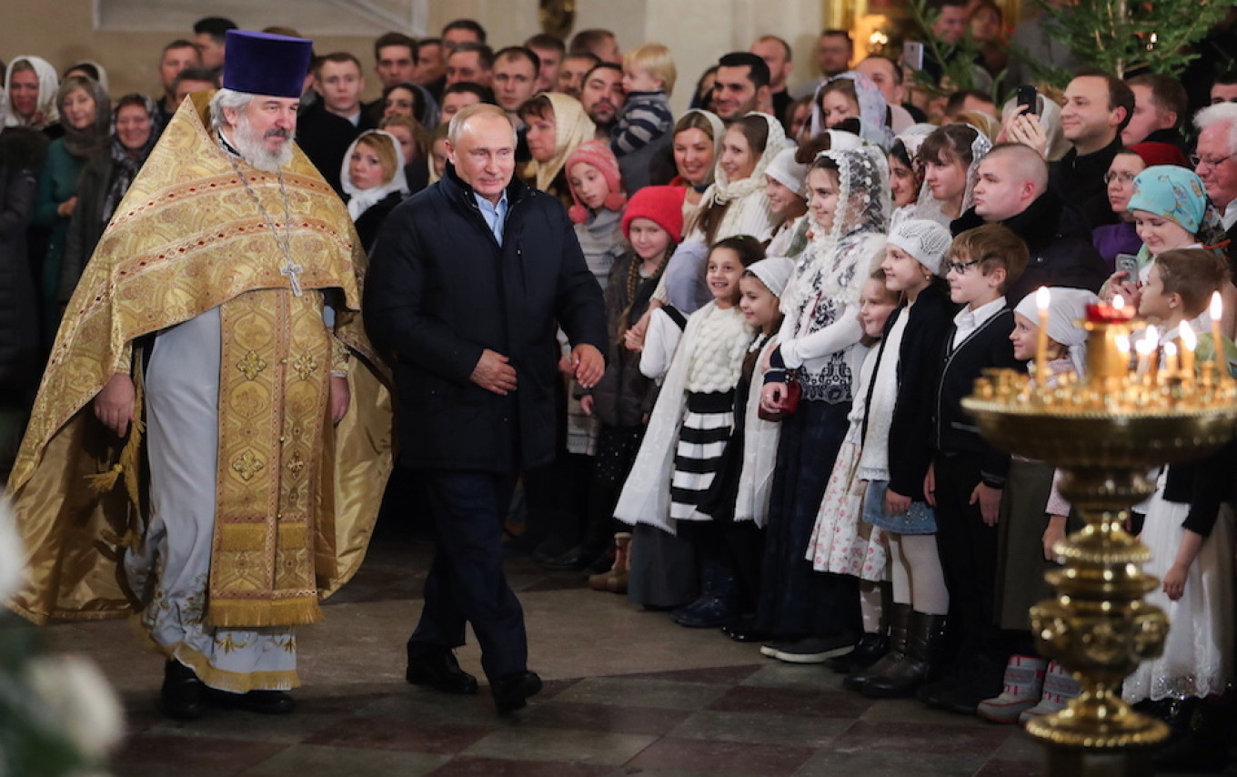 
					Putin walks past worshipers in Transfiguration Cathedral during the Christmas mass in St. Petersburg.					 					Alexander Demianchuk / TASS				