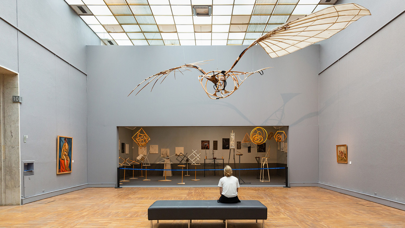 
					Vladimir Tatlin's "Letatlin" flying machine (1932) soaring above a reconstruction of the Society of Young Artist's constructivist exhibit of 1921.					 					Courtesy of the State Tretyakov Gallery				