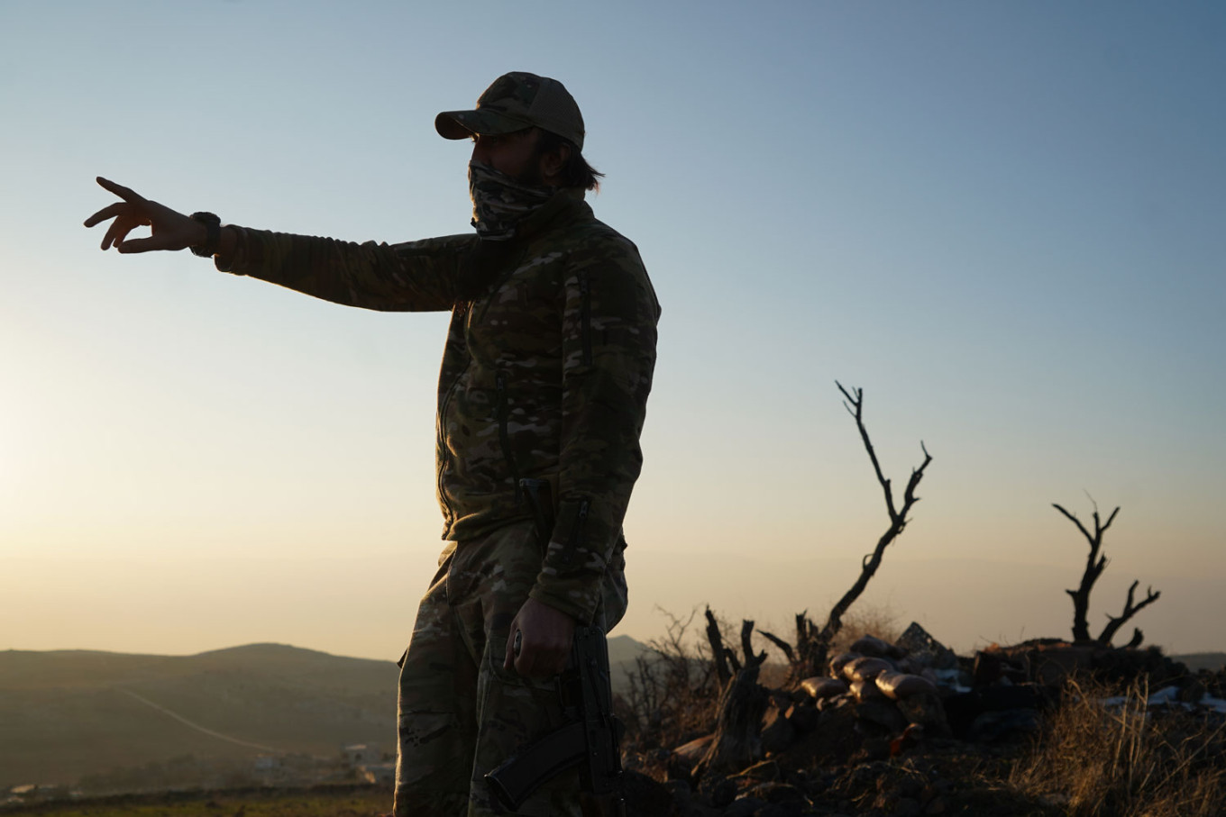 
					Abdullah, standing on their former position, points toward the horizon where Assad’s Russian-backed forces once stood.					 					Joseph Roche				