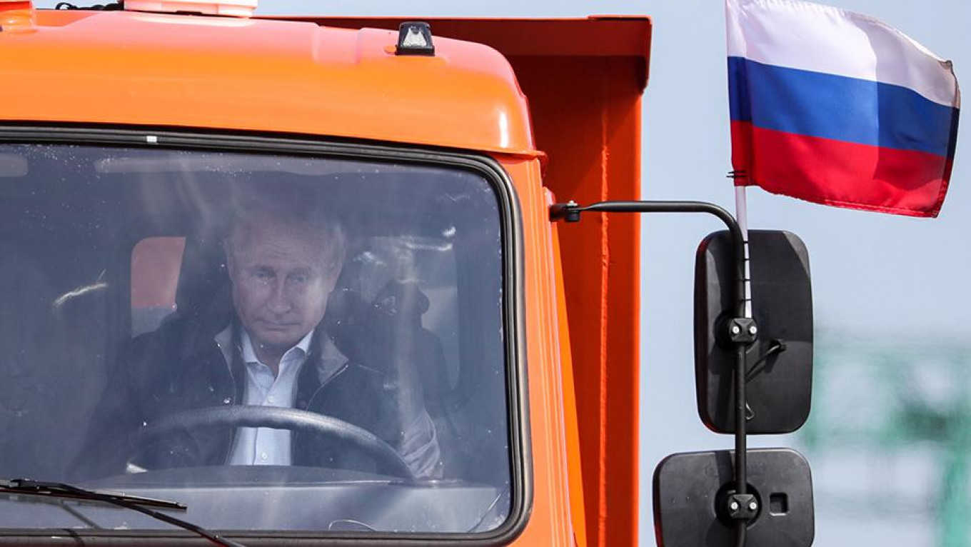 
					Putin drives a truck across the Crimean bridge during its unveiling.					 					Sergei Bobylev / TASS				