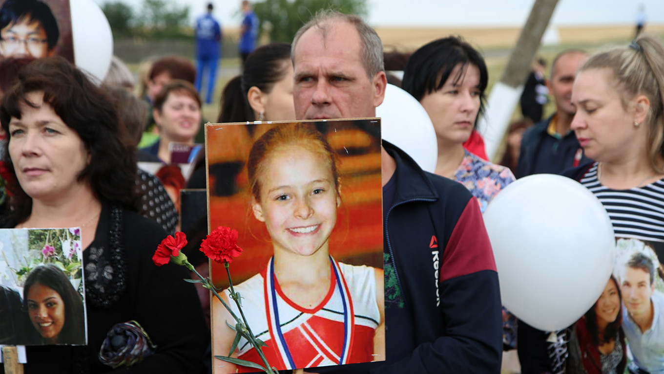 
					People hold portraits of victims at an event to mark the sixth anniversary of the downing of Malaysia Airlines Flight MH17.					 					Valentin Sprinchak / TASS				