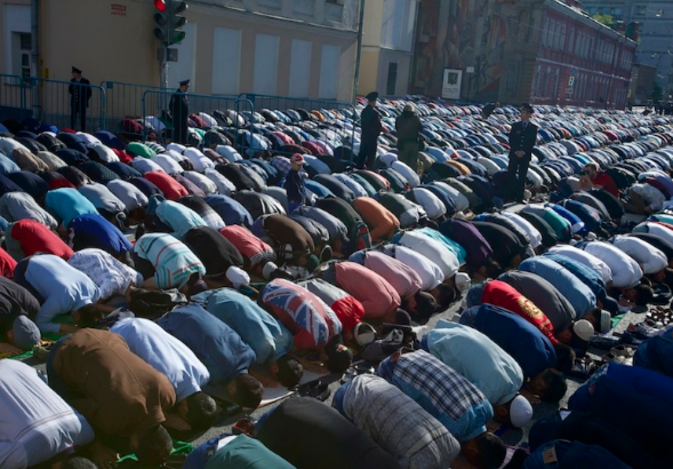 
					Police officers guard Muslims performing Eid al-Fitr prayers outside Moscow's Cathedral Mosque. 					 					Ivan Sekretarev / AP				