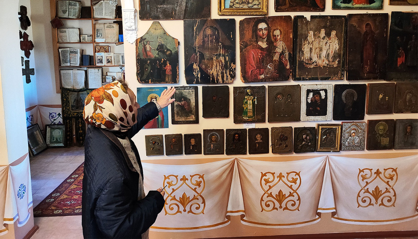
					Liubov Alekseevna shows a collection of icons in the sanctuary.					 					MT				