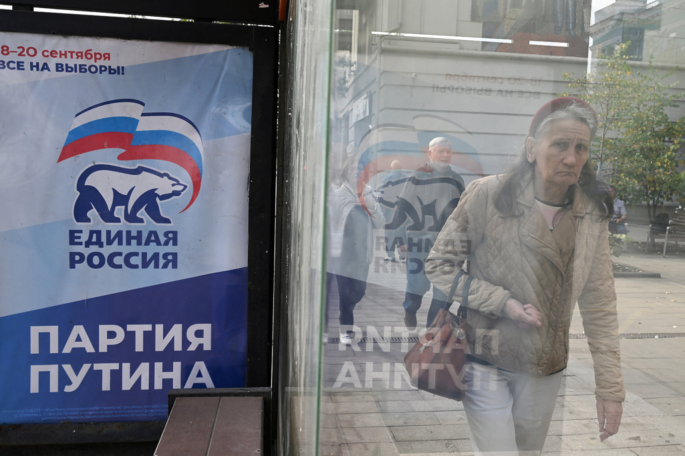 
					A woman walks past a campaign poster for the United Russia party in Krasnoyarsk.					 					REUTERS / Vladislav Nekrasov				