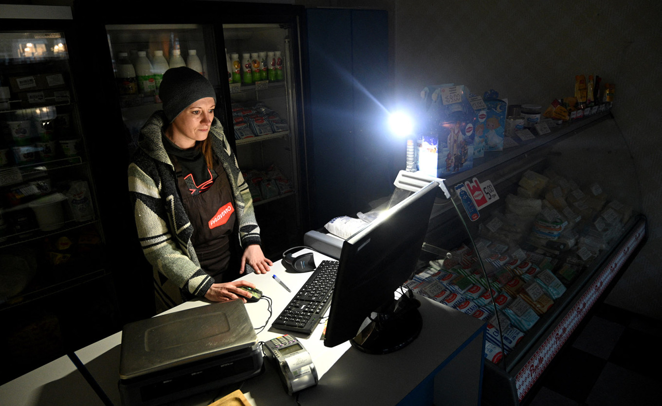 
					A seller waits for customers in a shop during a partial blackout in Lviv.					 					Yuriy Dyachyshyn / AFP				