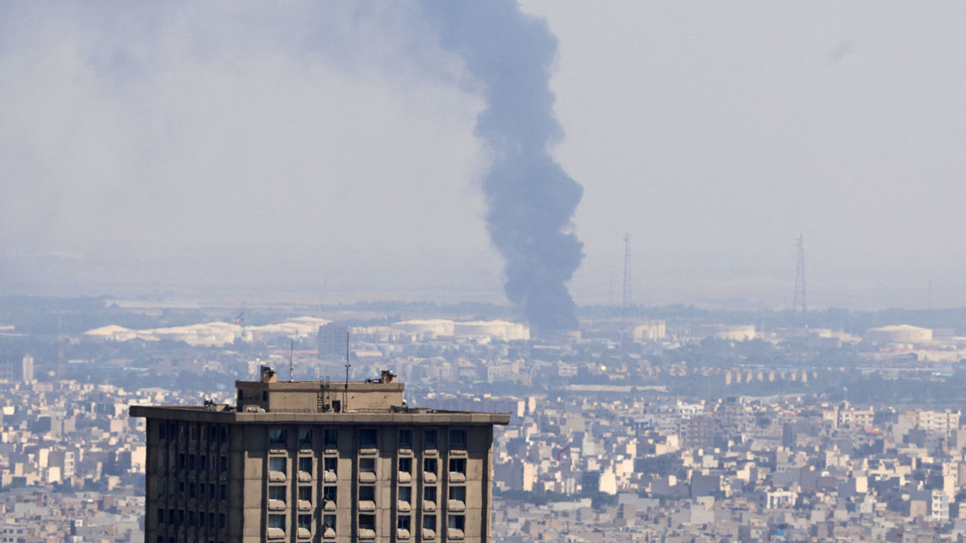 Smoke billows in the distance from an oil refinery following an Israeli strike on the Iranian capital Tehran. Atta Kenare / AFP