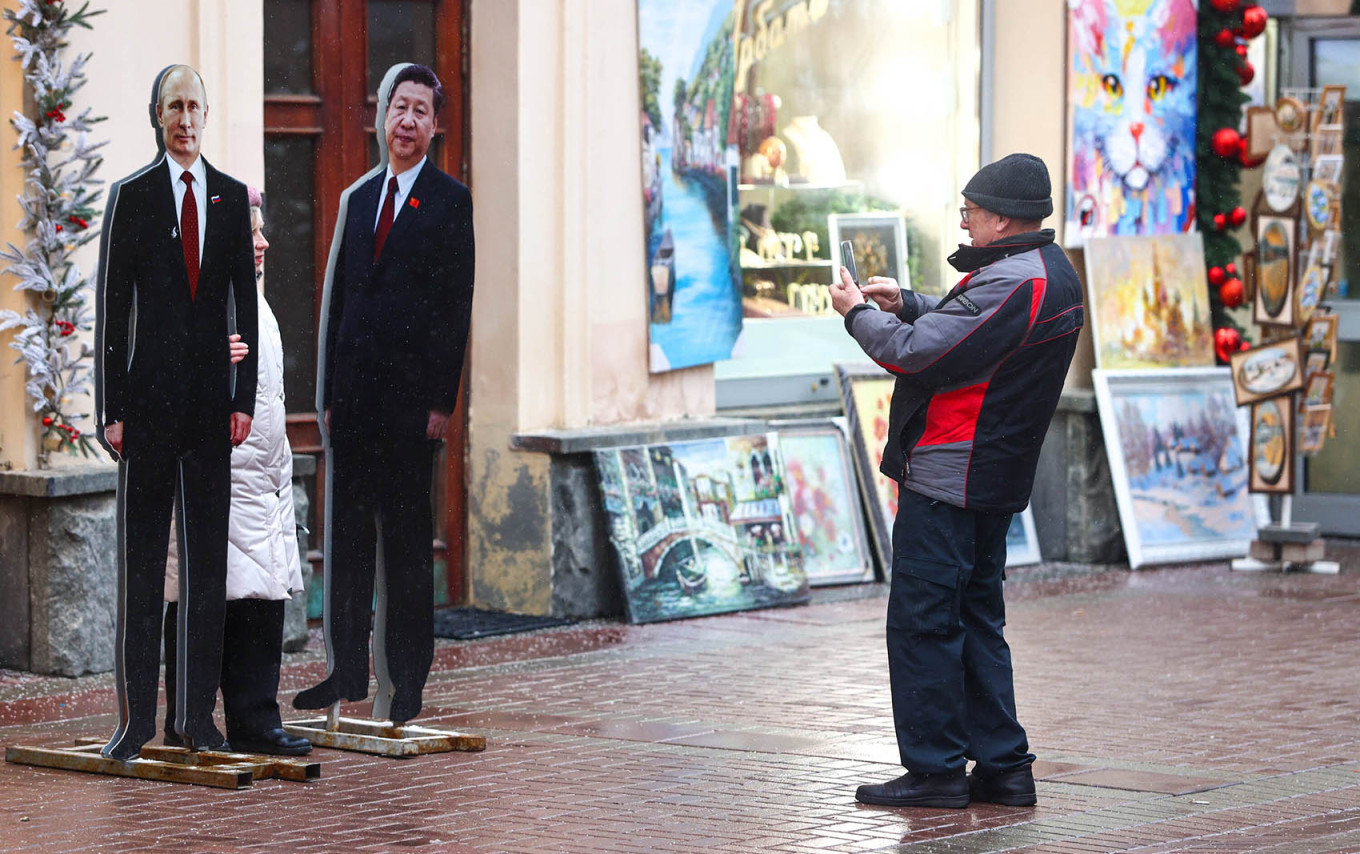 
					A man photographs cardboard cutouts of Vladimir Putin and Xi Jinping on Arbat Street in Moscow.					 					Yaroslav Chingaev / Moskva News Agency				