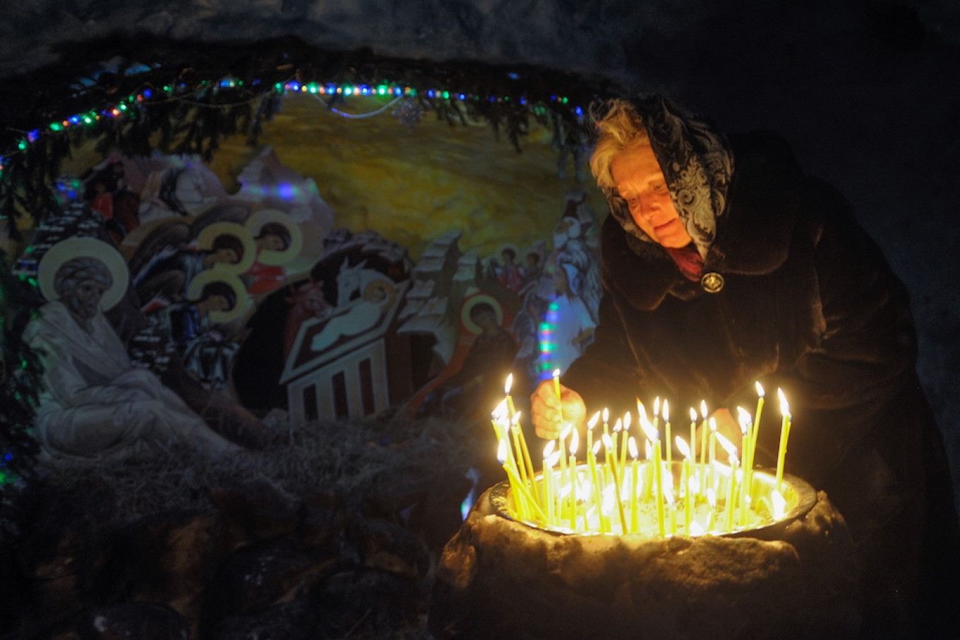 
					A woman lights candles in the Bogoyavlenskiy Cathedral in the Siberian city of Tomsk.					 					Taisiya Vorontsova / TASS				