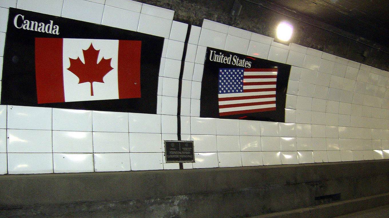 
					Flags of Canada and the United States over a metal boundary marker in the Detroit-Windsor Tunnel.					 					Mikerussell (CC BY-SA 3.0)				