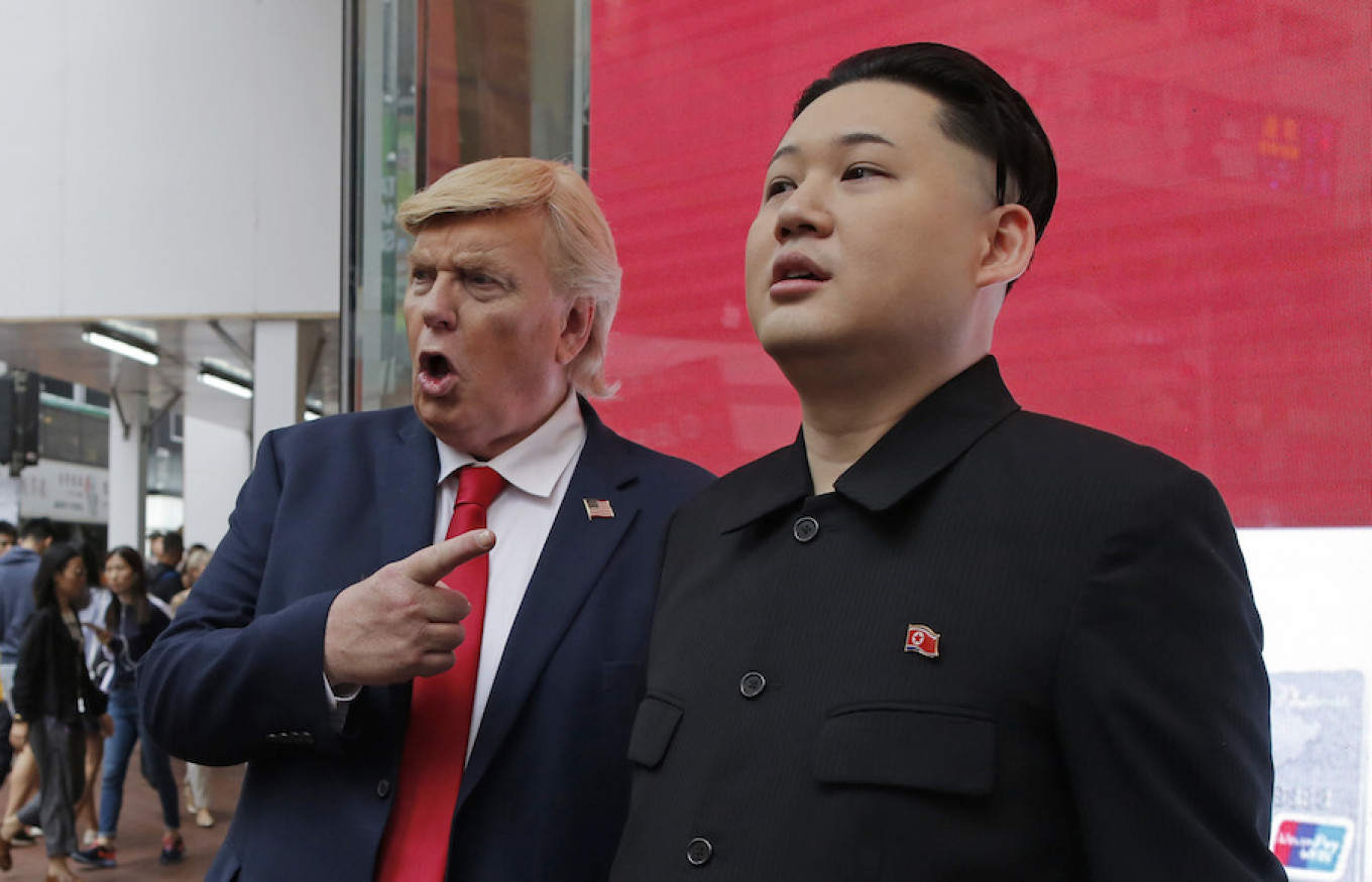 Peniru pemimpin Korea Utara Kim Jong Un (kanan) dan Presiden AS Donald Trump berpose di sebuah jalan di Hong Kong.  Kin Cheung / AP