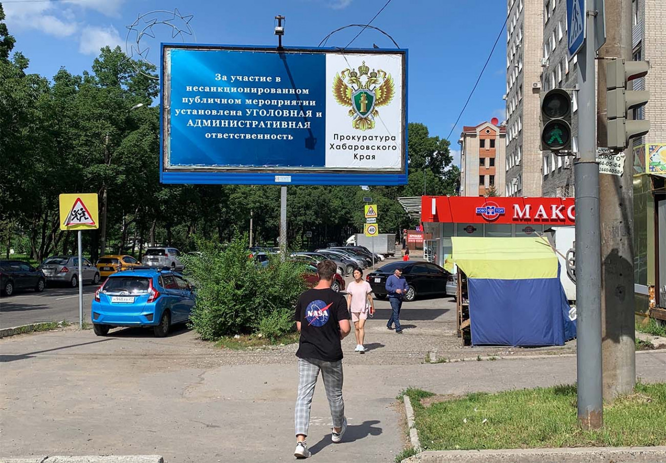 Papan reklame di sekitar pusat kota Khabarovsk memperingatkan penduduk bahwa mereka mungkin bertanggung jawab secara pidana karena bergabung dalam protes tanpa izin.  Evan Gershkovich / MT