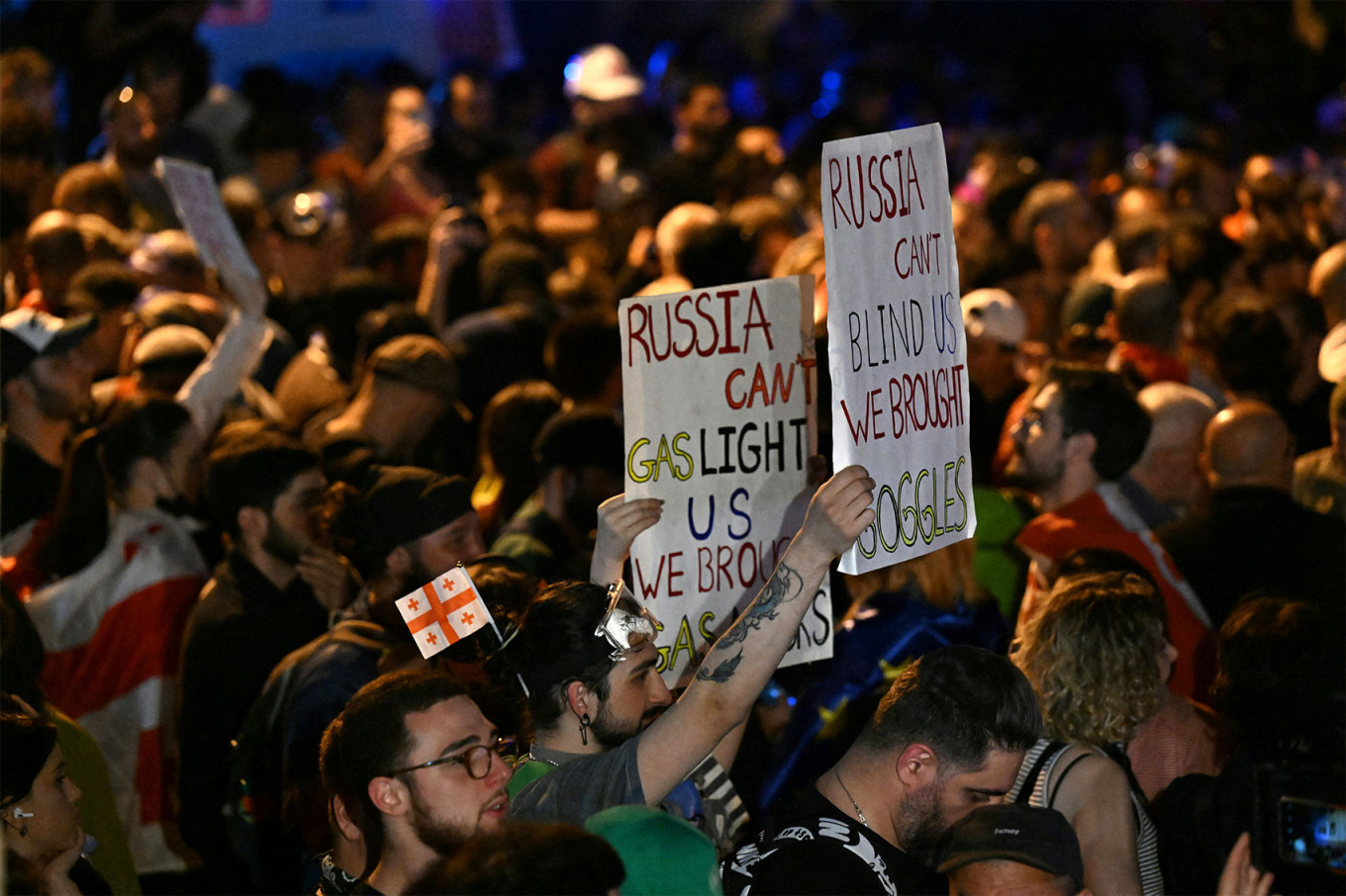 
					Demonstrators hold up anti-Russia posters as they rally against the "foreign influence" bill.					 					Vano Shlamov / AFP				