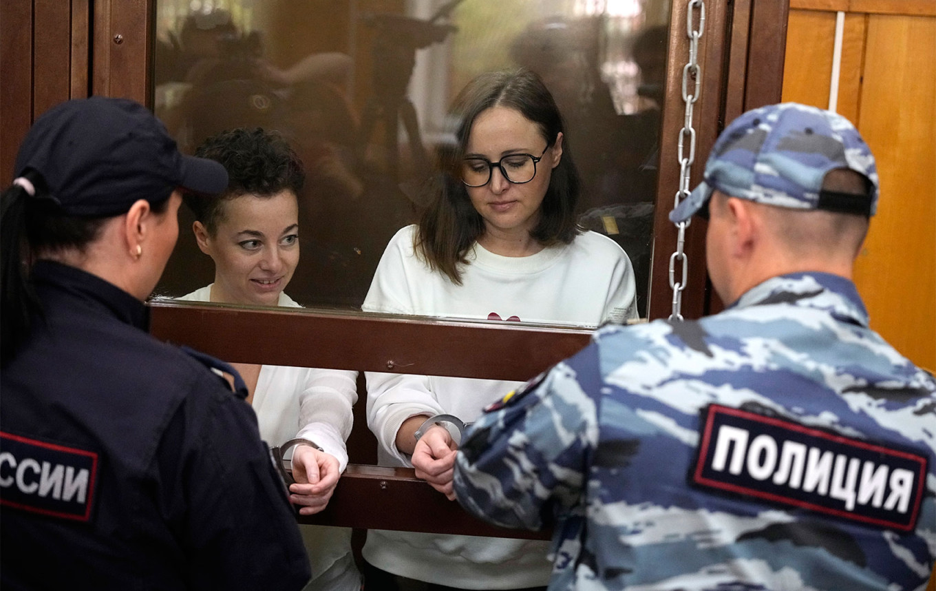 
					Theater director Zhenya Berkovich, left, and playwright Svetlana Petriychuk stand in a glass cage in a courtroom prior to a hearing in a court in Moscow.					 					Alexander Zemlianichenko / AP / TASS				