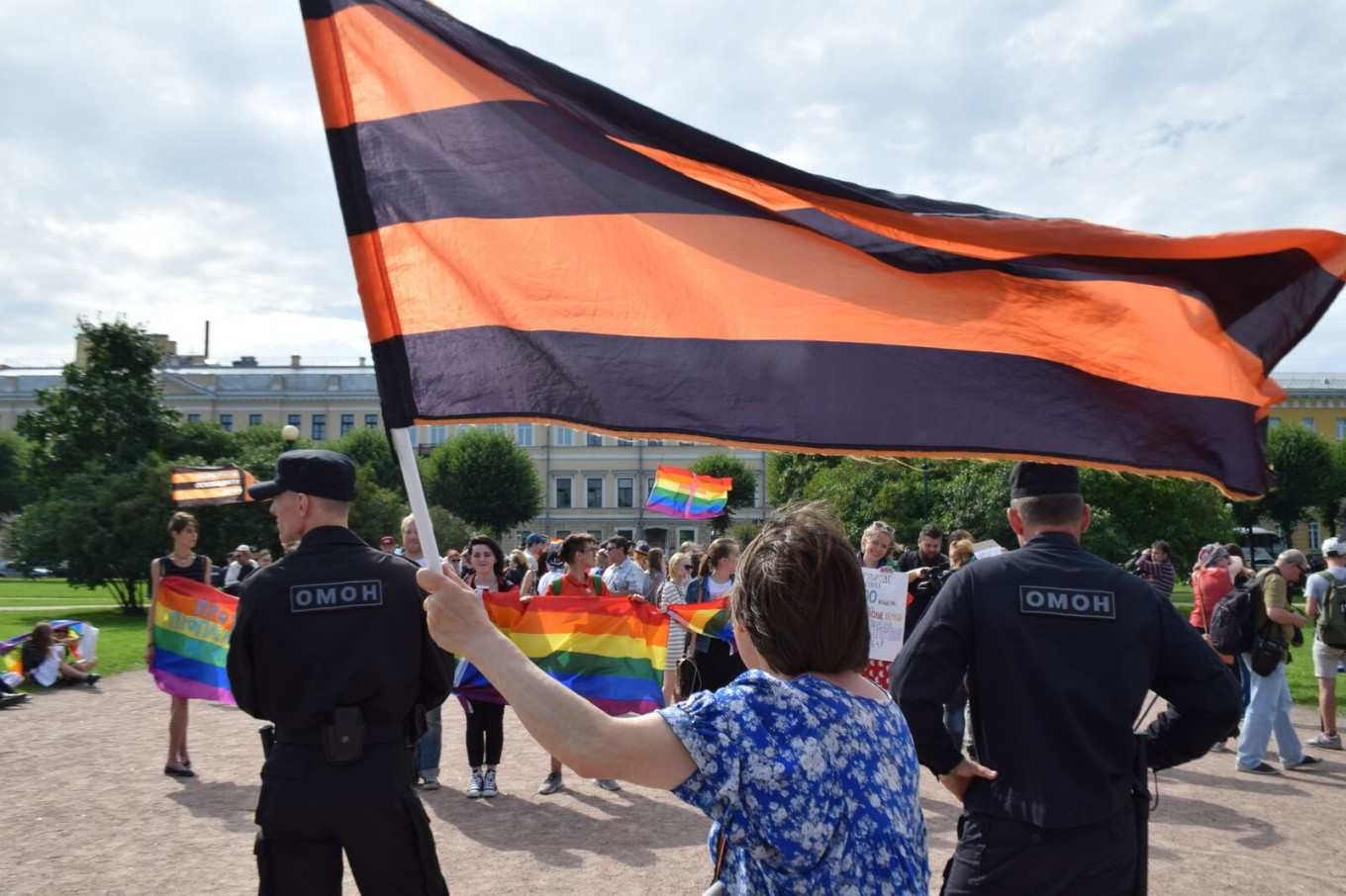 Segelintir pengunjuk rasa membawa bendera oranye-hitam St.  George's, simbol patriotisme Rusia, melambai saat mereka mengutuk kebanggaan LGBT.  Francesca Visser dan Andreas Rossbach