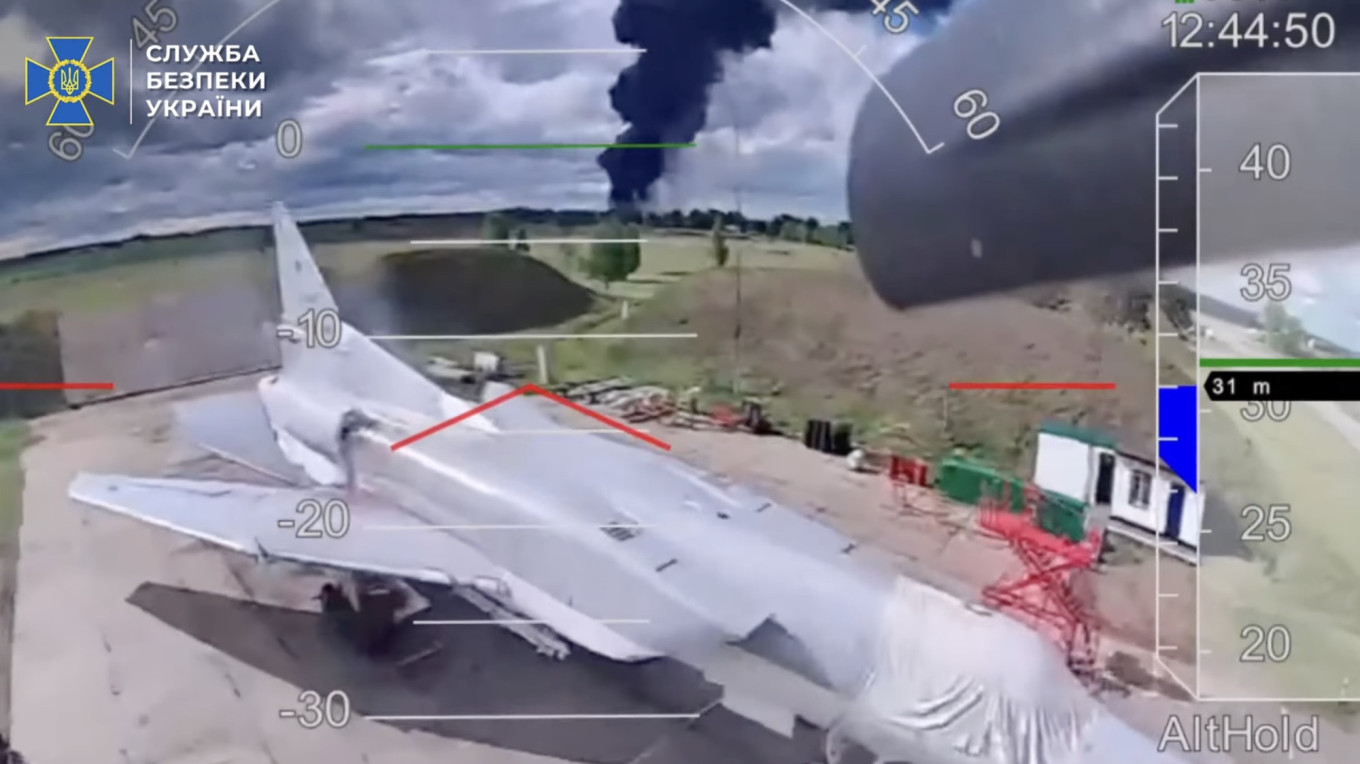 Smoke from a burning aircraft visible behind a Tu-22M3. Screenshot/SBU