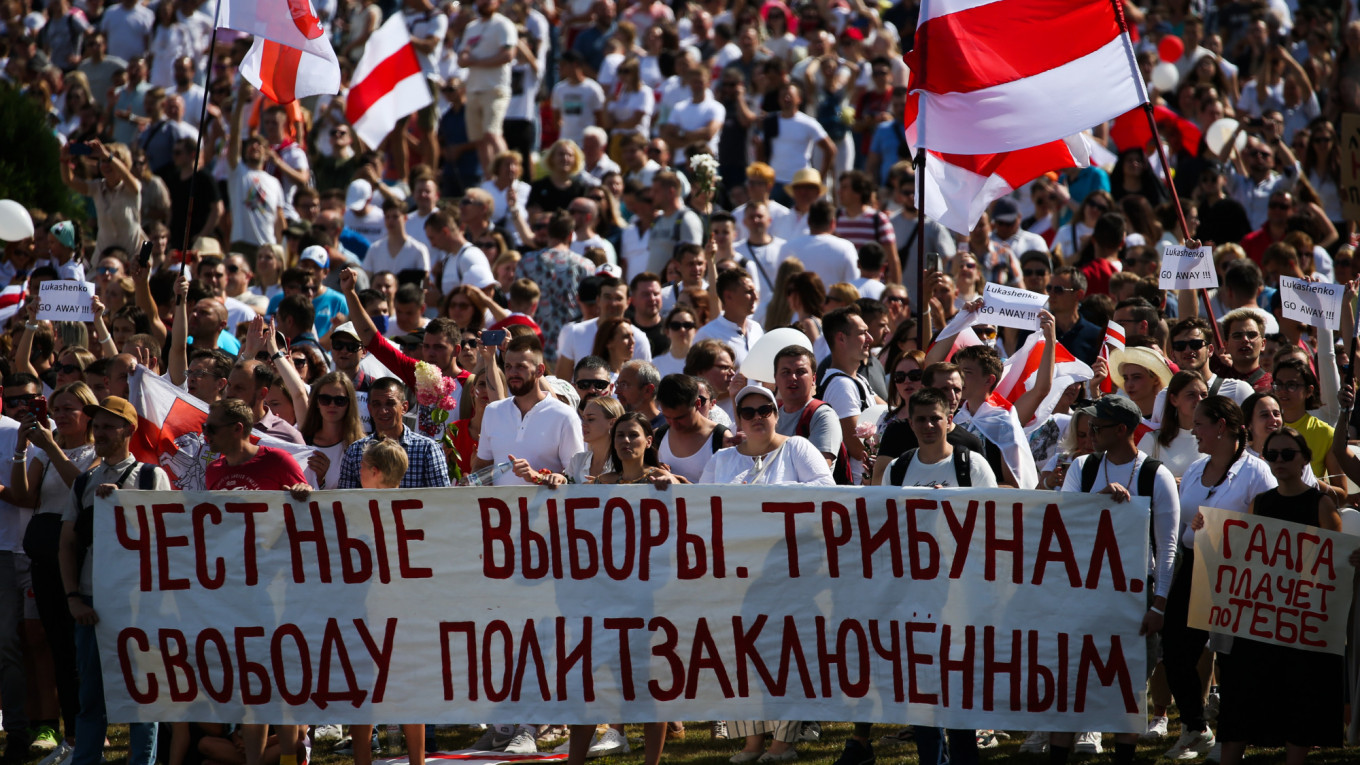 Protestors hold a sign, reading: “Fair Elections. Court trial. Freedom for political prisoners.”